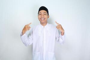 cheerful muslim asian man pointing to him self with smiling at camera, show its me gesture, isolated on white background photo