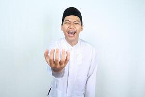 asian muslim man holding imaginary bowl with empty palm and laughing expression isolated on white background photo