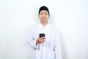 sad muslim asian man crying with holding phone isolated on white background photo