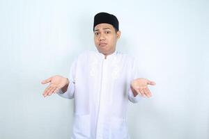 confused asian muslim man raising hand show i dont know gesture isolated on white background photo