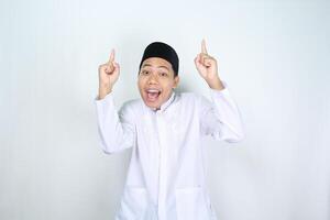 surprised asian muslim man pointing to above isolated on white background photo