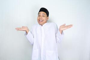 funny asian muslim man posing do not know gesture with surprised face expression isolated on white background photo