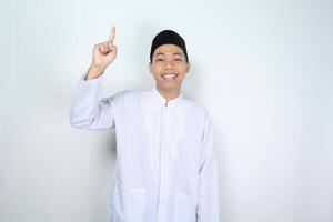 happy muslim asian man pointing up isolated on white background photo