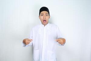 asian man muslim pointing over his chest and looking at camera with shocked expression isolated on white background photo
