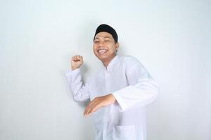 contento asiático musulmán hombre mirando a cámara con posando lanzamiento alguna cosa aislado en blanco antecedentes foto