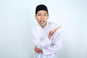 confused asian muslim man presenting to empty side isolated on white backround photo