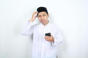 muslim asian man holding phone with touching his head feeling dizzy isolated photo