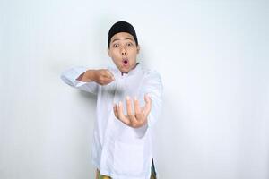 funny asian man muslim pointing to empty palm with shocked expression isolated on white background photo