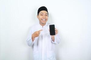 smiling asian muslim man pointing to phone screen display isolated photo