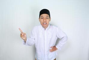 angry muslim asian man pointing to side isolated on white background photo