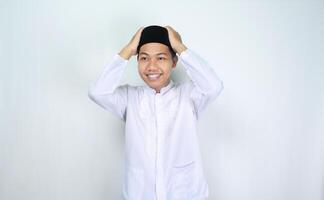 happy muslim asian man wearing kopiah, islamic skullcap, in eid mubarak celebration isolated on white background photo