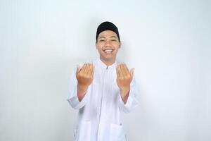 smiling muslim asian man show inviting gesture with looking at camera isolated on white background photo
