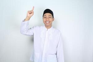 happy muslim asian man pointing up isolated on white background photo