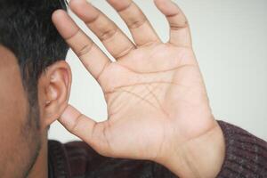 young man having ear pain touching his painful ear , photo