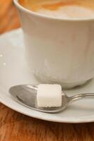 café taza y azúcar cubo en mesa foto