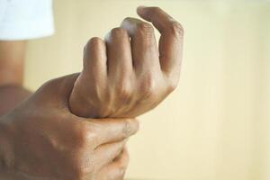 man suffering pain in hand close up photo