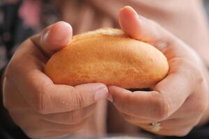 women hand pick baked bun on table photo