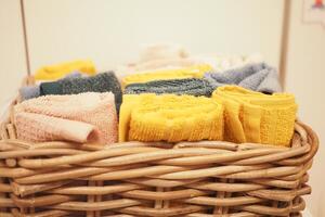 A storage basket made of wood filled with an assortment of towels photo