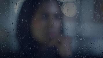 joven triste hembra persona desplazamientos en urbano ciudad pueblo en lloviendo clima video