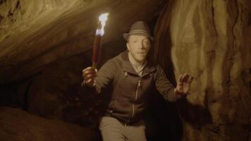 Man Holding A Burning Torchlight Exploring Forest Cave Landscape In Dark Night video