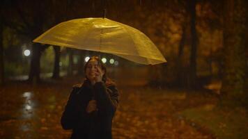 contento despreocupado mujer bailando con paraguas fuera de en lluvioso noche video