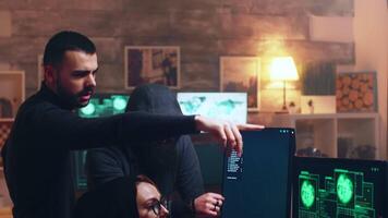 Team of hackers looking at computer with multiple monitors while committing cyber crimes. video