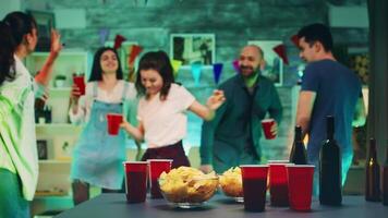 papas fritas y tazas con cerveza en el mesa con personas bailando en el antecedentes a el fiesta. video