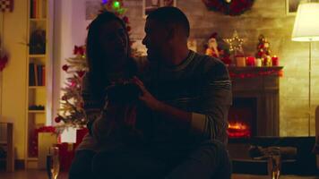 Beautiful young woman gives her handsome man a surprise gift on christmas day. Light comes out of the box. video