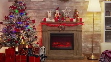 Natal árvore decorado com luzes e presente caixas. lareira queimando. video
