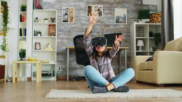 Cheerful little girl lying on the floor carpet with virtual reality headset. video