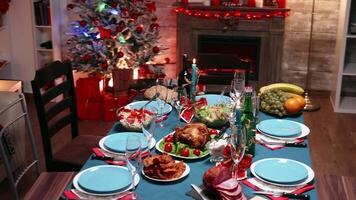 Top view of traditional food for christmas feast. Christmas table decoration. Xmas celebration in decorated room full of globe decorations and christmas tree with fireplace, big festive dinner meal for large family video