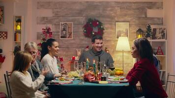 Adult man taking a photo with the family at christmas reunion. Happy family. Winter holidays. Traditional festive christmas dinner in multigenerational family. Enjoying xmas meal feast in decorated room. Big family reunion video
