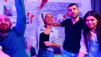 amico pieno di eccitazione danza nel davanti di telecamera a un' selvaggio Università festa con bene musica. video