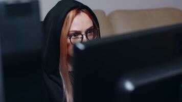 Revealing shot of wanted female hacker using super computer to write a malicious virus. video