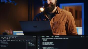 Focused computer scientist writing complex binary code scripts on laptop terminal. Remote IT support worker standing in home office, using programming to safeguard consumer data video