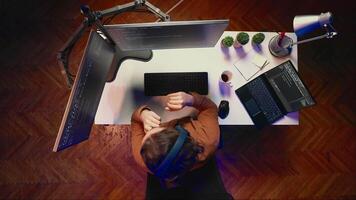 Aerial shot of frenzied programmer impatiently taping desk with fingers while writing code. Stressed IT expert doing multitasking in office, thinking how to solve database errors, top down view video