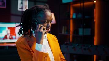 Student calling her professor to discuss about class materials, organizing study schedules and timelines based on online lessons. African american girl talking on smartphone call. Camera B. video