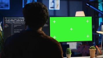 programmeur typen complex code Aan groen scherm computer in neon lit huis kantoor, ontwikkelen software sollicitatie. telewerken het specialist aan het doen afgelegen project taken Aan mockup pc monitor, camera een video