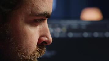 Developer in home office concentrating hard while doing coding on computer, extreme close up shot. Focus on IT admin paying close attention to screen while writing lines of code, camera A video