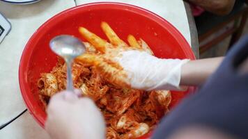 schließen oben Aussicht Prozess von Herstellung Kimchi im groß Schüssel mit Hand. Koreanisch Gurken, Kimchi. Frau Hand Mischen Gemüse ,Kimchi Soße und Würze Zutat zu machen Kimchi video