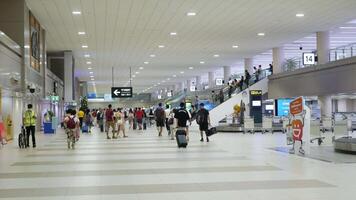 Crowded of passenger in arrival hall baggage claim area from inblound arring flight at Don muang international airport after opening country video