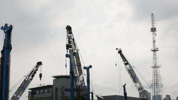 Construction building site with heavy euipment crane while working in sunset time in bangkok video