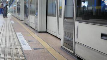 faible angle vue à le porte porte de le le métro porte train banlieusard sur Plate-forme à train station tandis que gens marcher par le porte, Taïwan Publique transport Contexte video