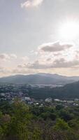 vertikal Timelapse antenn se av phuket stad stad horisont med många byggnader hus i de central företag distrikt med bakgrund av bukt område och marinmålning hav i dagtid. video