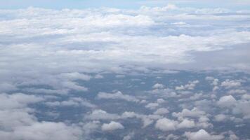 blue sky with white fluffy clouds from airplane flight fly over the clouds in a sunny day with cloud moving in the atmosphere in hot weather summer time. video