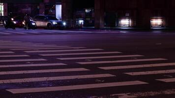 lasso di tempo Basso angolo Visualizza per il asfalto attraversamento strada a intersezione la zona nel notte tempo con affollato di persone pedone attraversare strada video