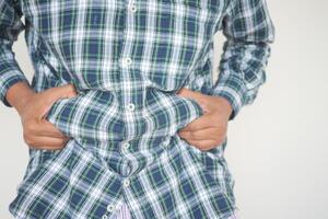 man's hand holding excessive belly fat, overweight concept photo