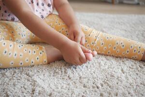 child girl suffering pain on feet photo