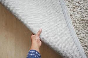 person hand rolling out new rug. photo