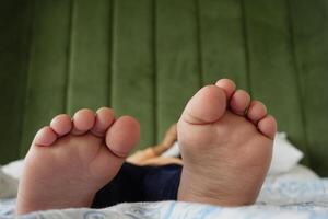 5 5 año antiguo niño niña pies dormido en el cama foto